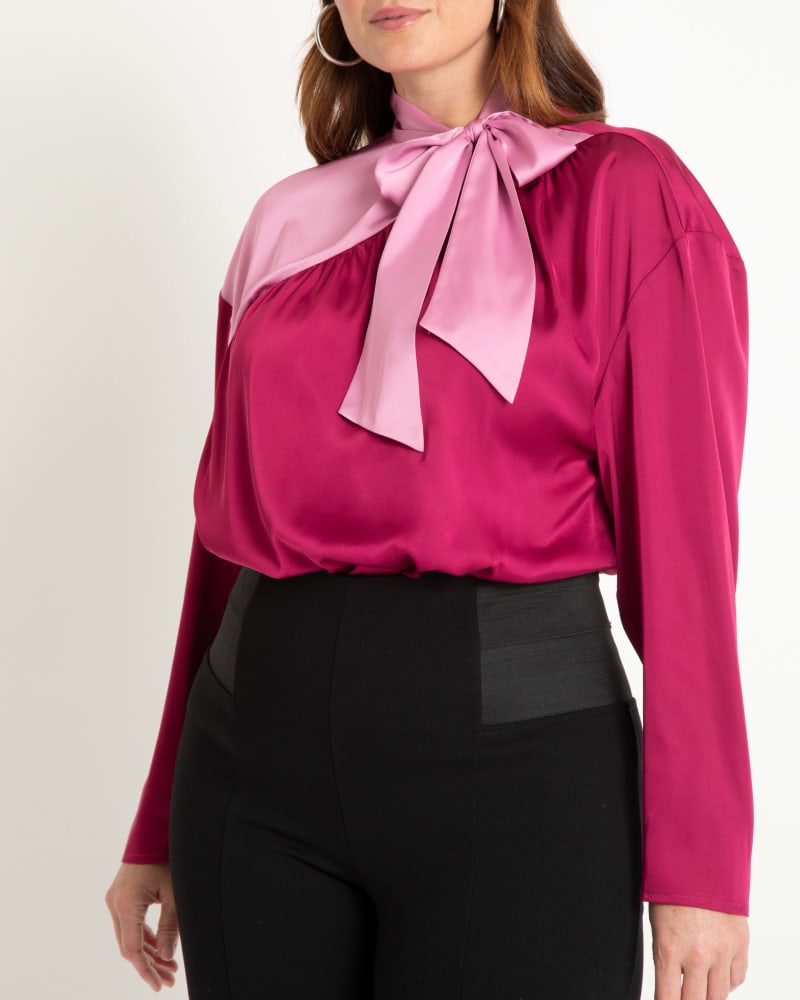 Front of a model wearing a size 22 Colorblocked Tie Neck Blouse in Grape And Lavender by ELOQUII. | dia_product_style_image_id:290227